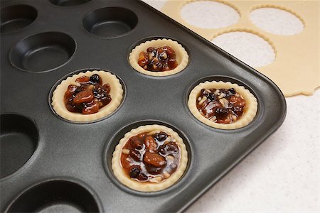simsearch:400-06693299,k - Producing mince pies; four pastry cases filled with mincemeat, dough scraps beyond Stockbilder - Microstock & Abonnement, Bildnummer: 400-07677937