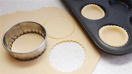 simsearch:400-06693299,k - Cutting large circles of pastry to line a bun tin Stockbilder - Microstock & Abonnement, Bildnummer: 400-07677933