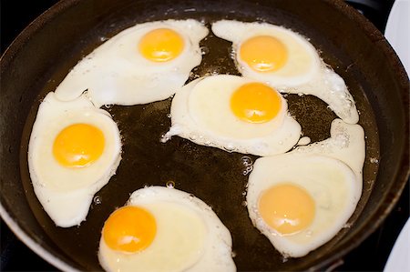 stockarch (artist) - High-angle close-up of six fried eggs, nutritious source of proteins, in a pan with hot oil, for breakfast Foto de stock - Royalty-Free Super Valor e Assinatura, Número: 400-07678856
