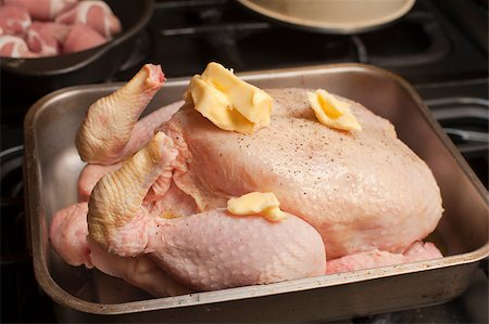 stockarch (artist) - Uncooked seasoned turkey topped with dollops of butter in a roasting pan or oven dish waiting to be placed in the oven for roasting Foto de stock - Royalty-Free Super Valor e Assinatura, Número: 400-07678857