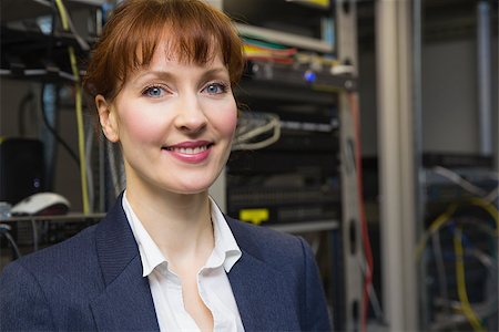 simsearch:400-07684490,k - Pretty computer technician smiling at camera beside open server in large data center Foto de stock - Super Valor sin royalties y Suscripción, Código: 400-07684392