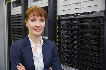 Pretty technician smiling at camera beside server tower in large data center Stock Photo - Budget Royalty-Free & Subscription, Code: 400-07684409