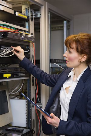 simsearch:400-07684490,k - Pretty technician using tablet pc while fixing server in large data center Foto de stock - Super Valor sin royalties y Suscripción, Código: 400-07684402