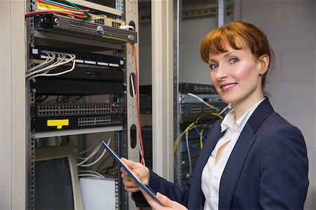 Pretty technician using tablet pc while fixing server in large data center Stock Photo - Budget Royalty-Free & Subscription, Code: 400-07684403