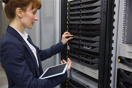 Pretty technician using tablet pc while working on servers in large data center Stock Photo - Budget Royalty-Free & Subscription, Code: 400-07684417