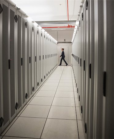 data center walking - Technician walking in server hallway in large data center Stock Photo - Budget Royalty-Free & Subscription, Code: 400-07684431