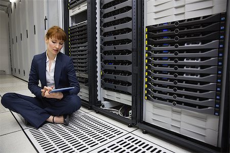data center tablet - Technician sitting on floor beside server tower using tablet pc in large data center Stock Photo - Budget Royalty-Free & Subscription, Code: 400-07684440