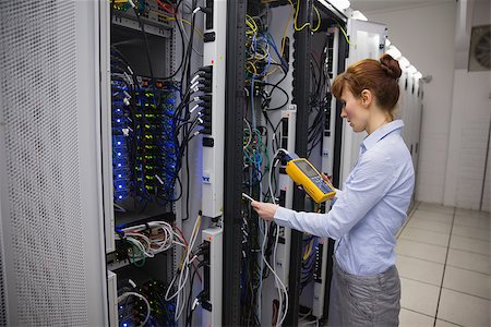 Happy technician using digital cable analyzer on server in large data center Stock Photo - Budget Royalty-Free & Subscription, Code: 400-07684476