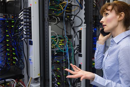 Technician talking on phone while analysing server in large data center Stock Photo - Budget Royalty-Free & Subscription, Code: 400-07684484