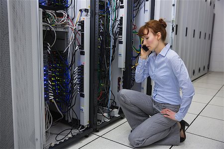 Technician talking on phone while analysing server in large data center Stock Photo - Budget Royalty-Free & Subscription, Code: 400-07684487