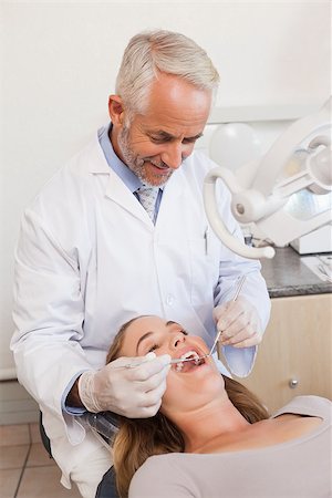 dental work - Dentist examining a patients teeth in the dentists chair at the dental clinic Stock Photo - Budget Royalty-Free & Subscription, Code: 400-07684696