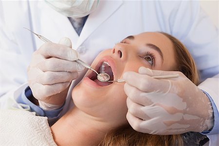 dental work - Dentist examining a patients teeth in the dentists chair at the dental clinic Stock Photo - Budget Royalty-Free & Subscription, Code: 400-07684706