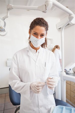 female with dental tools at work - Dentist examining her tools on a tray looking at camera at the dental clinic Stock Photo - Budget Royalty-Free & Subscription, Code: 400-07684740