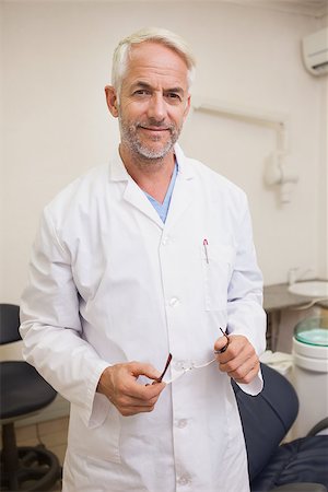 standing next to chair - Dentist smiling at camera beside chair at the dental clinic Stock Photo - Budget Royalty-Free & Subscription, Code: 400-07684808