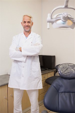 standing next to chair - Dentist smiling at camera beside chair at the dental clinic Stock Photo - Budget Royalty-Free & Subscription, Code: 400-07684803