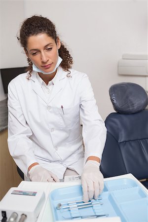 simsearch:400-07941454,k - Dentist picking up a tool beside the chair at the dental clinic Stockbilder - Microstock & Abonnement, Bildnummer: 400-07684823