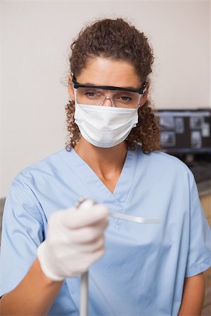 female dentist with gloves and mask - Dentist in mask and protective glasses holding drill at the dental clinic Foto de stock - Super Valor sin royalties y Suscripción, Código: 400-07684844