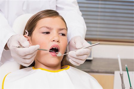 simsearch:400-07684901,k - Pediatric dentist examining a patients teeth in the dentists chair at the dental clinic Stock Photo - Budget Royalty-Free & Subscription, Code: 400-07684864