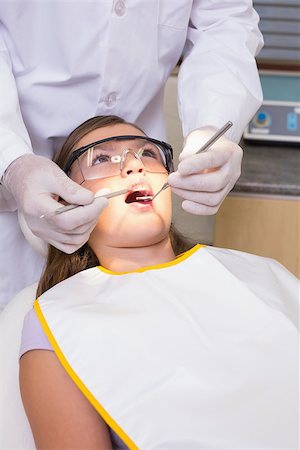 simsearch:400-07684901,k - Pediatric dentist examining a patients teeth in the dentists chair at the dental clinic Stock Photo - Budget Royalty-Free & Subscription, Code: 400-07684866