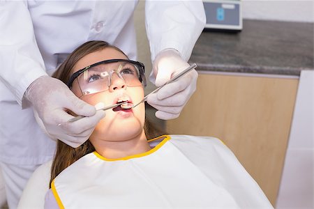 simsearch:400-07684901,k - Pediatric dentist examining a patients teeth in the dentists chair at the dental clinic Stock Photo - Budget Royalty-Free & Subscription, Code: 400-07684867