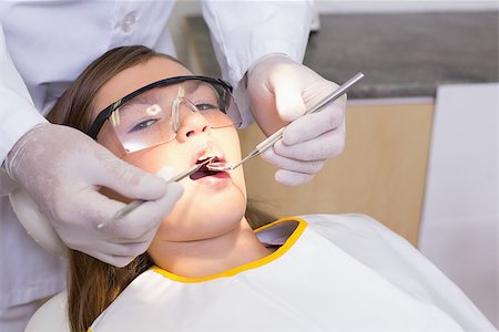 simsearch:400-07684901,k - Pediatric dentist examining a patients teeth in the dentists chair at the dental clinic Stock Photo - Budget Royalty-Free & Subscription, Code: 400-07684868