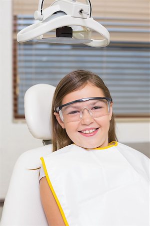 dentist bib girl - Little girl sitting in dentists chair wearing protective glasses at the dental clinic Stock Photo - Budget Royalty-Free & Subscription, Code: 400-07684885