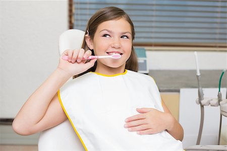 dentist bib girl - Little girl holding toothbrush in dentists chair at the dental clinic Stock Photo - Budget Royalty-Free & Subscription, Code: 400-07684895