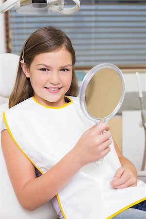 dentist bib girl - Little girl holding mirror in dentists chair at the dental clinic Stock Photo - Budget Royalty-Free & Subscription, Code: 400-07684900
