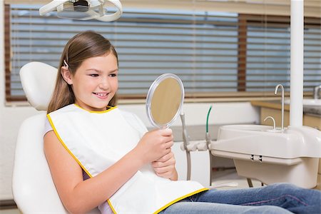 dentist bib girl - Little girl holding mirror in dentists chair at the dental clinic Stock Photo - Budget Royalty-Free & Subscription, Code: 400-07684902
