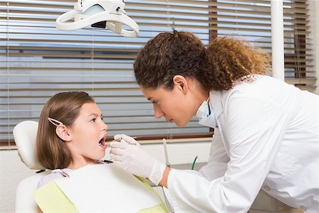 simsearch:400-07684901,k - Pediatric dentist examining little girls teeth in the dentists chair at the dental clinic Stock Photo - Budget Royalty-Free & Subscription, Code: 400-07684925