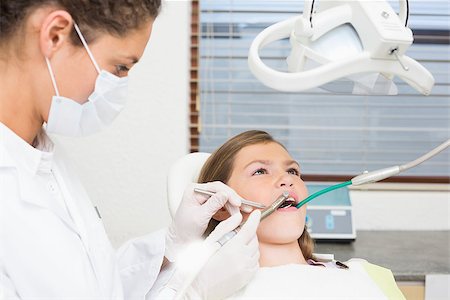 simsearch:400-07684901,k - Pediatric dentist examining little girls teeth in the dentists chair at the dental clinic Stock Photo - Budget Royalty-Free & Subscription, Code: 400-07684929