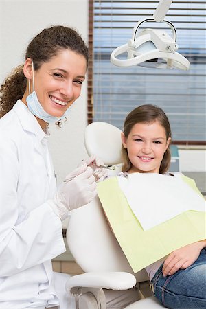 simsearch:400-07684901,k - Pediatric dentist and little girl in the dentists chair smiling at camera at the dental clinic Stock Photo - Budget Royalty-Free & Subscription, Code: 400-07684932