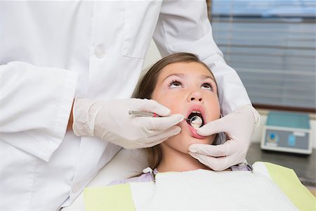 simsearch:400-07684901,k - Pediatric dentist examining a little girls teeth in the dentists chair at the dental clinic Stock Photo - Budget Royalty-Free & Subscription, Code: 400-07684946