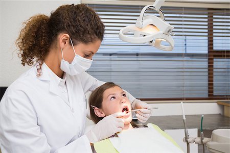 simsearch:400-07684901,k - Pediatric dentist examining a little girls teeth in the dentists chair at the dental clinic Stock Photo - Budget Royalty-Free & Subscription, Code: 400-07684949