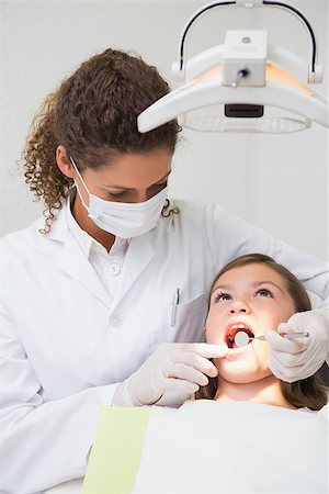 simsearch:400-07684901,k - Pediatric dentist examining a little girls teeth in the dentists chair at the dental clinic Stock Photo - Budget Royalty-Free & Subscription, Code: 400-07684950