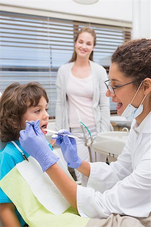 dentist child - Pediatric dentist examining a little boys teeth with his mother watching at the dental clinic Stock Photo - Budget Royalty-Free & Subscription, Code: 400-07685012