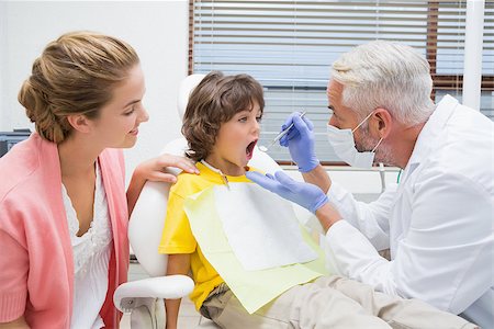 dentist child - Pediatric dentist examining a little boys teeth with his mother watching at the dental clinic Stock Photo - Budget Royalty-Free & Subscription, Code: 400-07685023