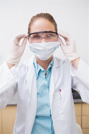 simsearch:400-07941465,k - Dentist putting on her protective glasses at the dental clinic Stock Photo - Budget Royalty-Free & Subscription, Code: 400-07685062