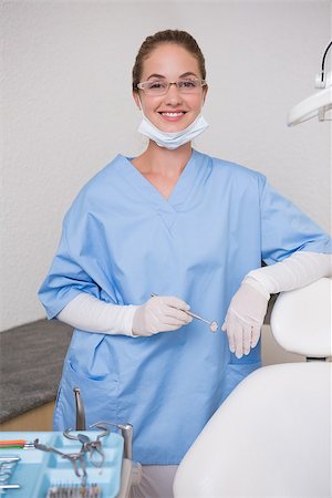 simsearch:400-07941454,k - Dentist in blue scrubs smiling at camera at the dental clinic Stockbilder - Microstock & Abonnement, Bildnummer: 400-07685074