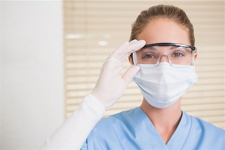 female dentist with gloves and mask - Dentist in surgical mask and protective glasses looking at camera at the dental clinic Stock Photo - Budget Royalty-Free & Subscription, Code: 400-07685079