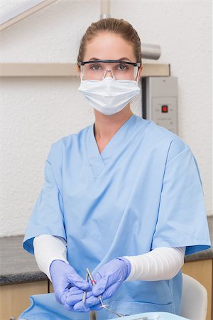 female with dental tools at work - Dentist in blue scrubs holding dental tools at the dental clinic Stock Photo - Budget Royalty-Free & Subscription, Code: 400-07685102