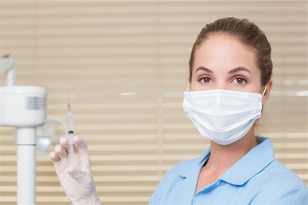 simsearch:400-07941454,k - Dental assistant holding injection looking at camera at the dental clinic Stockbilder - Microstock & Abonnement, Bildnummer: 400-07685116