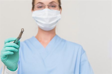 dental drill - Dentist in blue scrubs holding drill looking at camera at the dental clinic Stock Photo - Budget Royalty-Free & Subscription, Code: 400-07685111