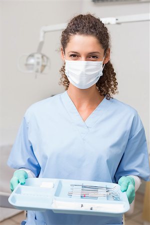 simsearch:400-07941454,k - Dentist in blue scrubs holding tray of tools at the dental clinic Stockbilder - Microstock & Abonnement, Bildnummer: 400-07685178