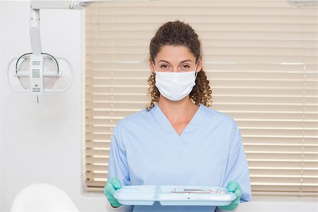 simsearch:400-07941454,k - Dentist in blue scrubs holding tray of tools at the dental clinic Stockbilder - Microstock & Abonnement, Bildnummer: 400-07685179