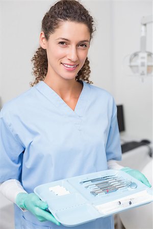 simsearch:400-07941454,k - Dentist in blue scrubs holding tray of tools at the dental clinic Stockbilder - Microstock & Abonnement, Bildnummer: 400-07685184