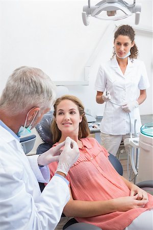 dentist and dental assistant relationship - Dentist examining a patients teeth in the dentists chair with assistant at the dental clinic Stock Photo - Budget Royalty-Free & Subscription, Code: 400-07685207