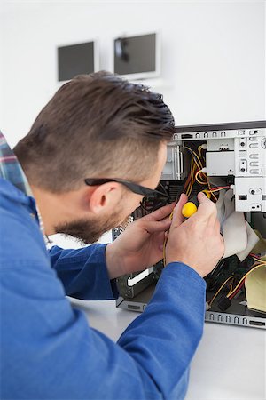 engineer at desk - Computer engineer working on broken console with screwdriver in his office Stock Photo - Budget Royalty-Free & Subscription, Code: 400-07685268