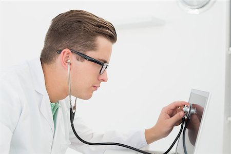 simsearch:400-05244427,k - Technician listening to laptop with stethoscope in his office Stock Photo - Budget Royalty-Free & Subscription, Code: 400-07685494