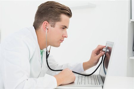 simsearch:400-05244427,k - Technician listening to laptop with stethoscope in his office Stock Photo - Budget Royalty-Free & Subscription, Code: 400-07685495